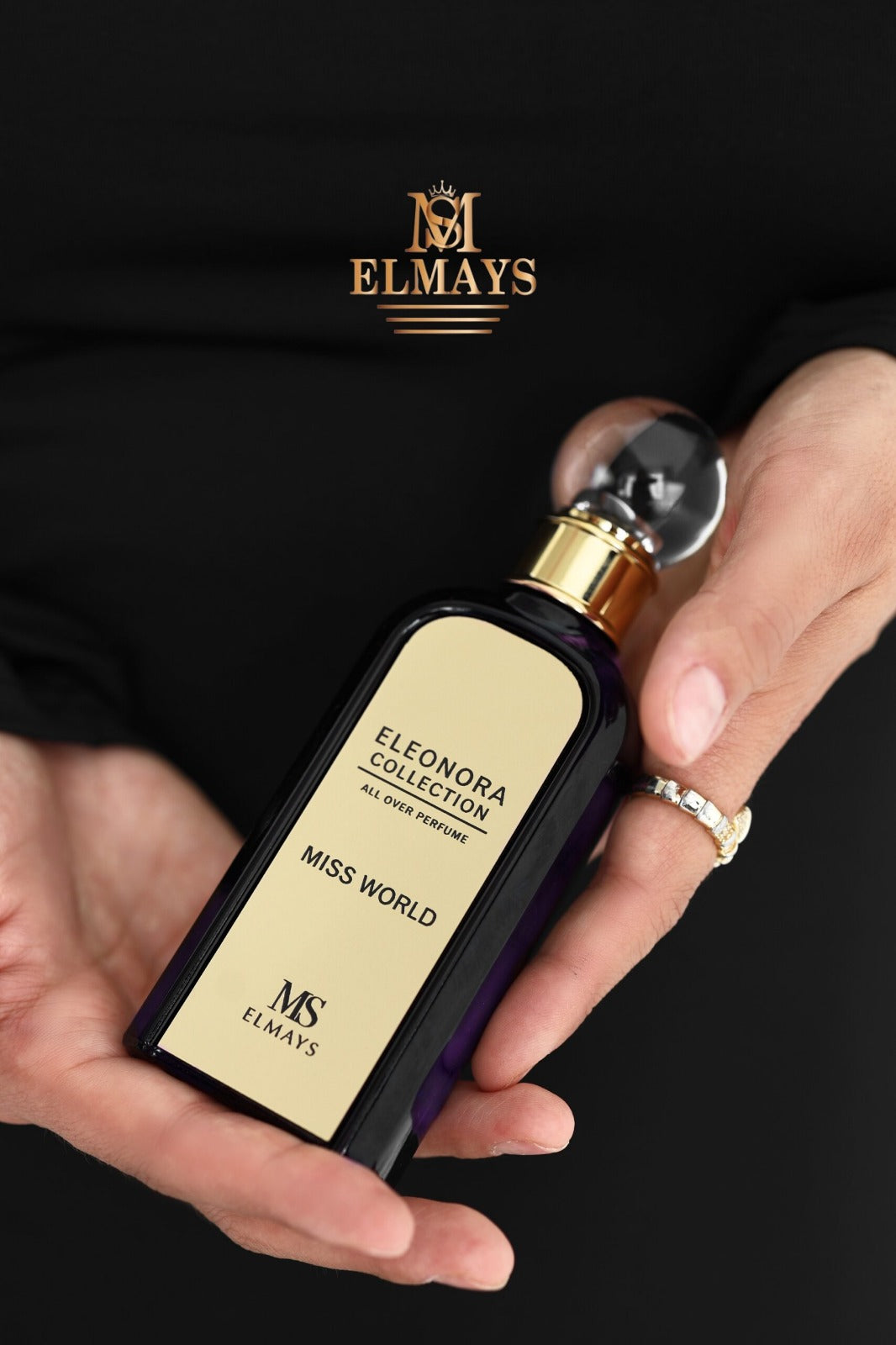 Woman holding a perfume bottle with Elmays branding