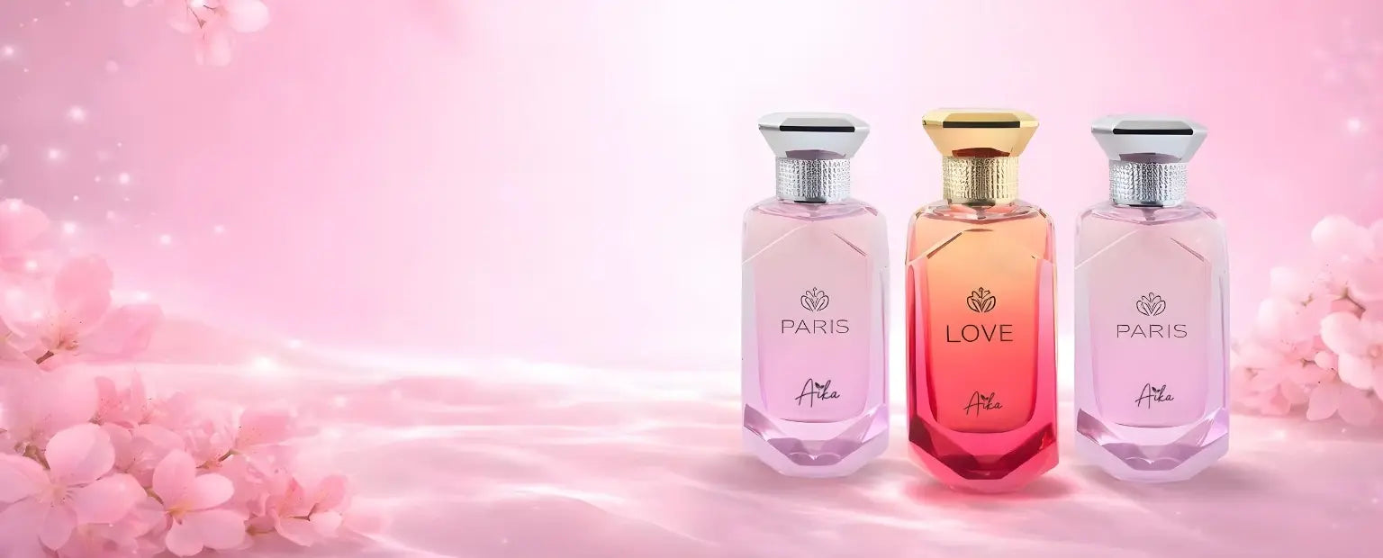 Three perfume bottles labeled 'PARIS', 'LOVE', and 'PARIS' on a pink floral background.